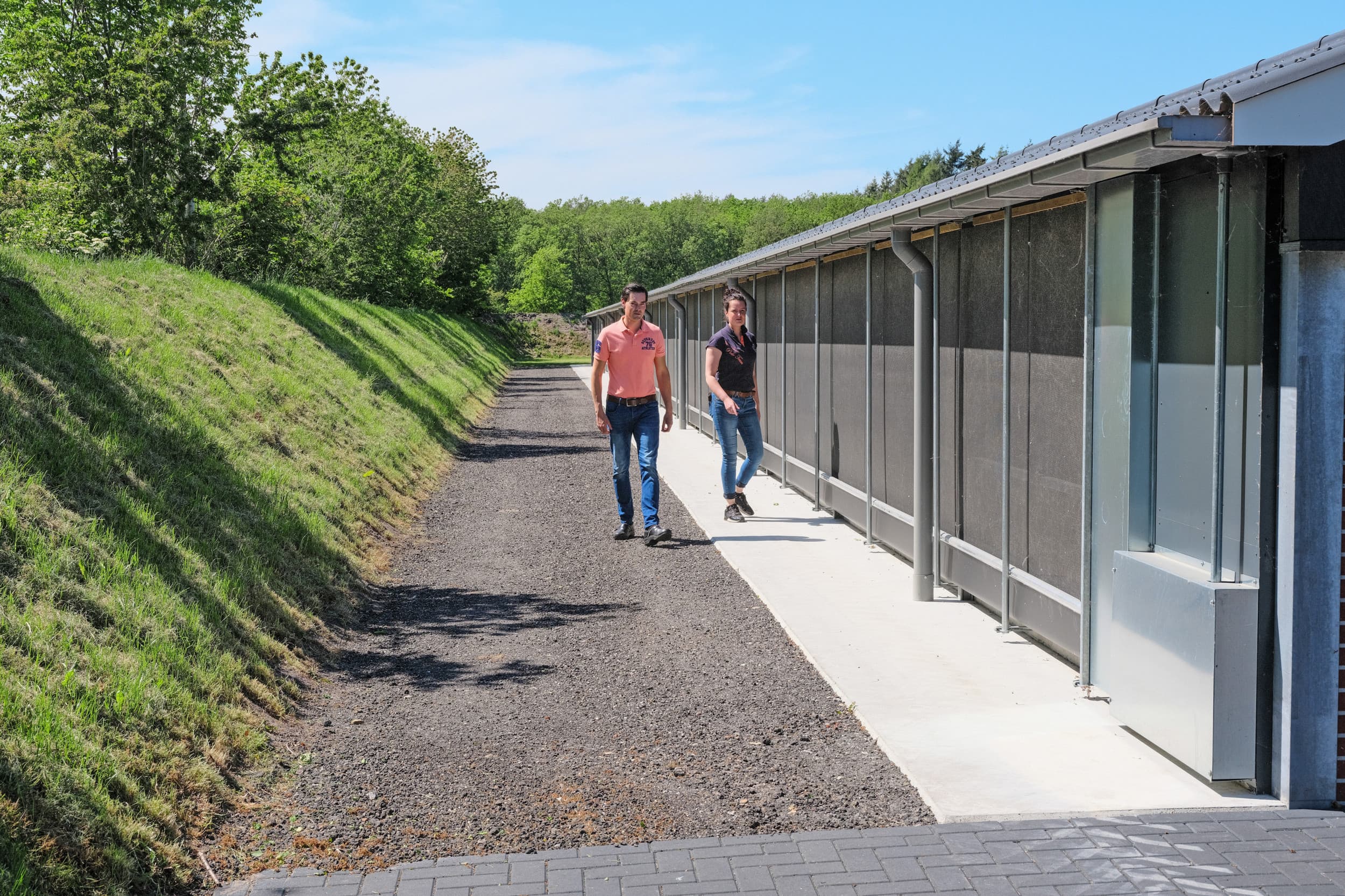 Gerben en Annemiek Greidanus bij de scharrelruimte. Stroken beton en gebroken asfalt weren ongedierte. – Foto’s: Jan Willem van Vliet