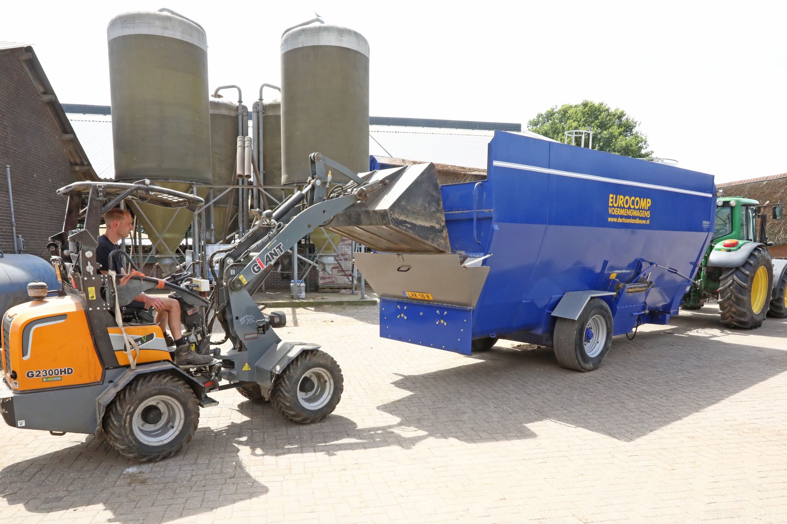 De veldbonen worden in een slurf opgeslagen. Rik van der Weele voert de veldbonen gedurende de winter met de voermengwagen. Hij gebruikt een shoveltje om de mengwagen te vullen. – Foto’s: Henk Riswick