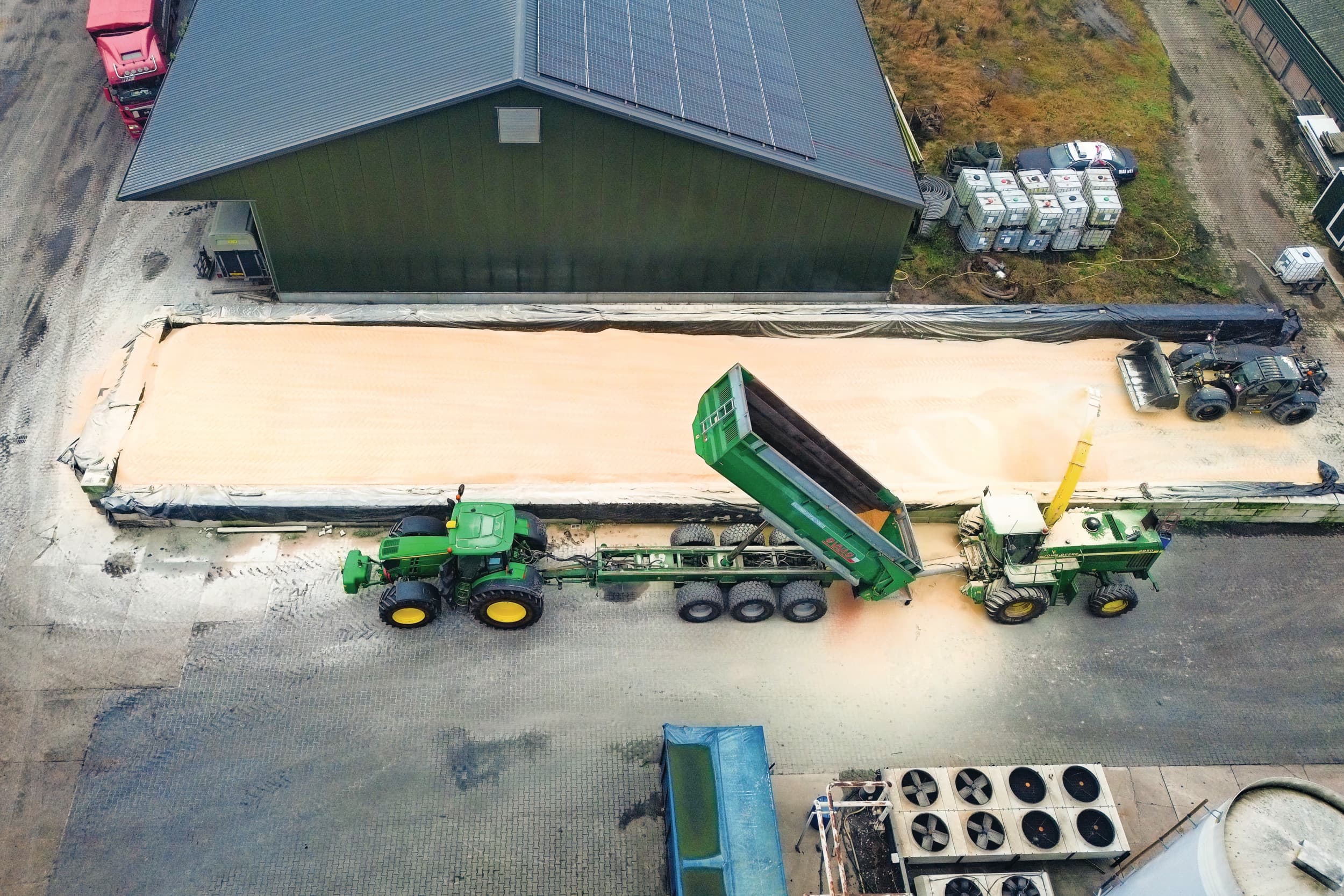 Naast de sleufsilo staat een hakselaar met korrelkneuzer opgesteld. Die blaast de gekneusde korrels de bult in. Foto: Jan Willem van Vliet