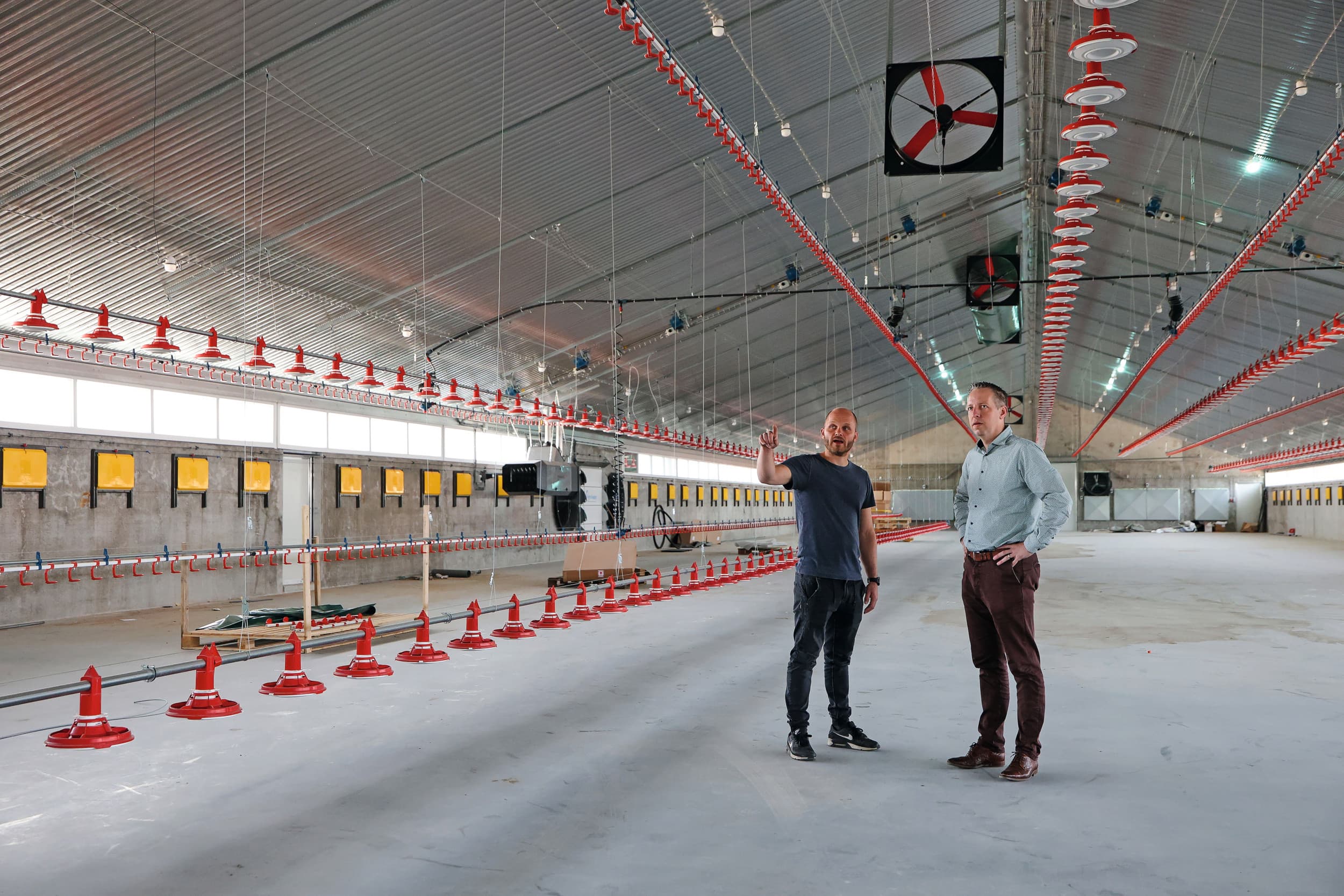 Dennis van Gastel (links) en Niels Geraerts van VDL Agrotech bekijken de stand van zaken in de nieuwe vleeskuikenstal. Bij het ontwerp en keuzes is Van Gastel niet over één nacht ijs gegaan. Voor VDL is het een ideale locatie om bezoekers met systemen in de praktijk kennis te laten maken. Foto’s: Bert Jansen