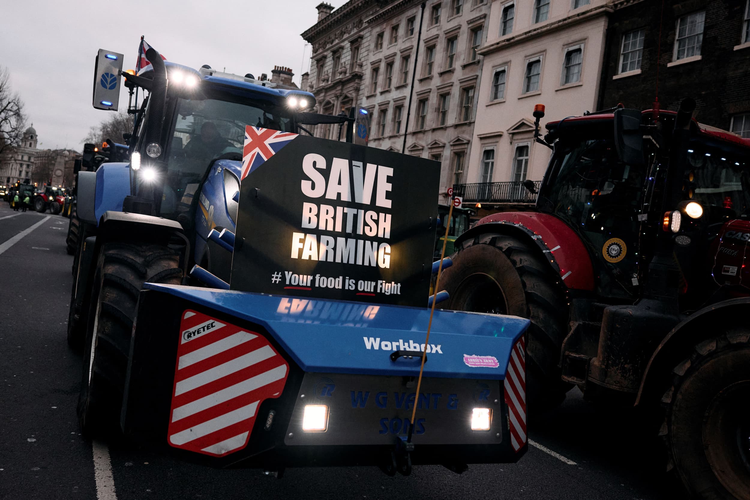 Een boer rijdt met zijn trekker door Londen tijdens een protest tegen versoberde erfbelastingregels, met een bord: "Save British Farming". Foto: ANP/AFP