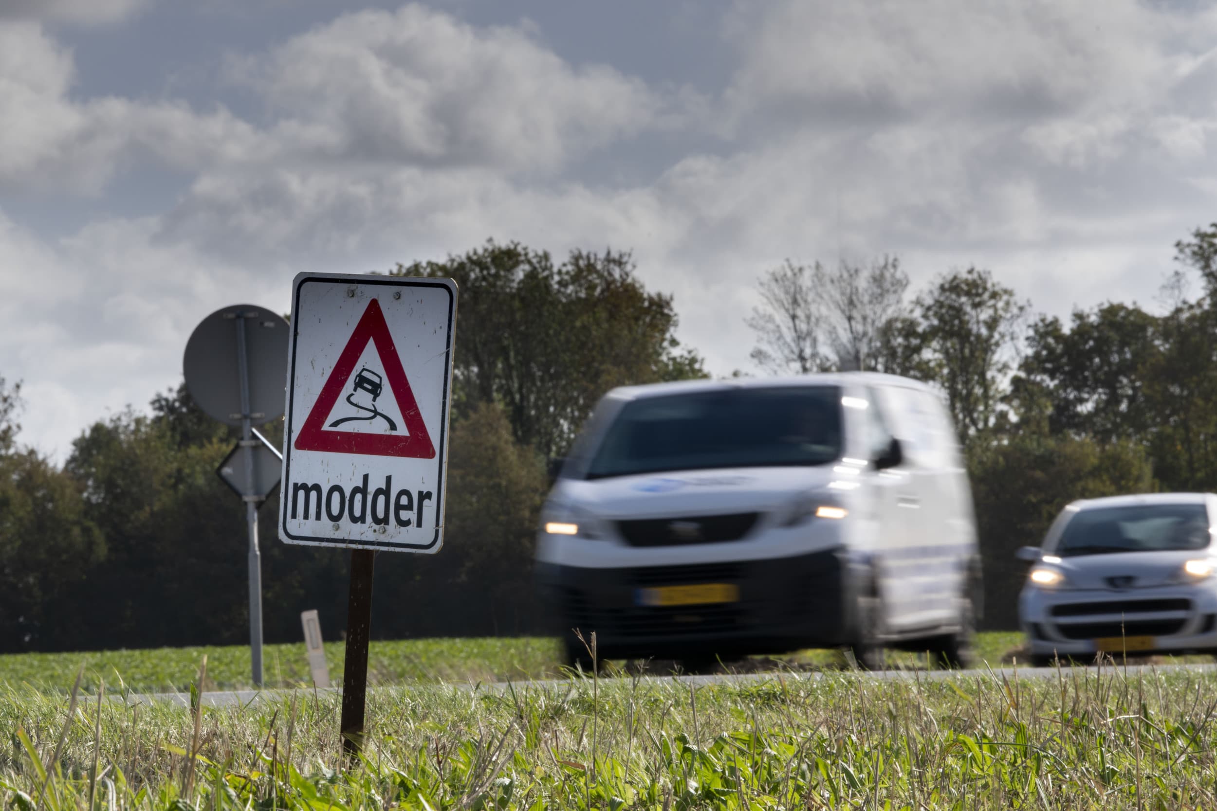 Spandoek ‘Modder op de weg’ waarschuwt in oogsttijd voor slipgevaar; boeren moeten volgens de regels altijd schoonmaken, ook bij droog weer. Foto: Mark Pasveer
