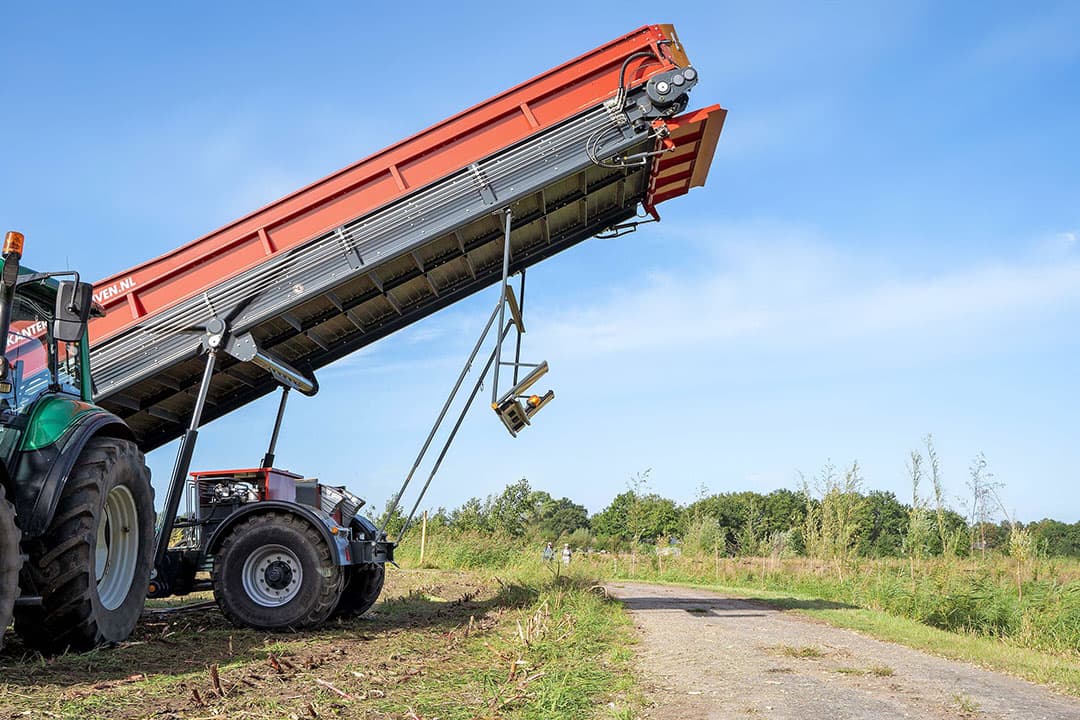 De 5,5 meter doorrijhoogte is ruim voldoende voor trailers. Detail: het klepje aan het eind van de band maakt links en rechts doseren mogelijk en voorkomt dat mais wegwaait bij harde wind.