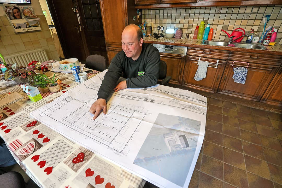 Rob Meeuwissen laat aan de hand van de bouwtekening zien hoe de toekomstige bewaarschuur eruit gaat zien. - Foto: Bert Jansen