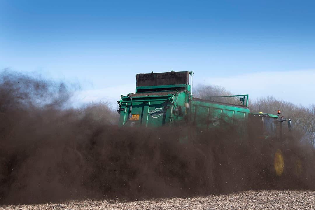 Loonwerker Jacob Molema strooit compost op een perceel van akkerbouwer Meilof Feiken in Oude Pekela (Gr.). De teler laat zo’n 20 ton gft-compost per hectare uit eigen opslag uitrijden. De vroege consumptieaardappelen heeft Feiken er al in en hij verwacht deze week zijn uien en bieten te kunnen zaaien en dan verder te gaan met de rest van de aardappelen. De grond is goed opgedroogd en als het weer zo blijft, lijkt het een vroeg jaar te worden. - Foto: Mark Pasveer