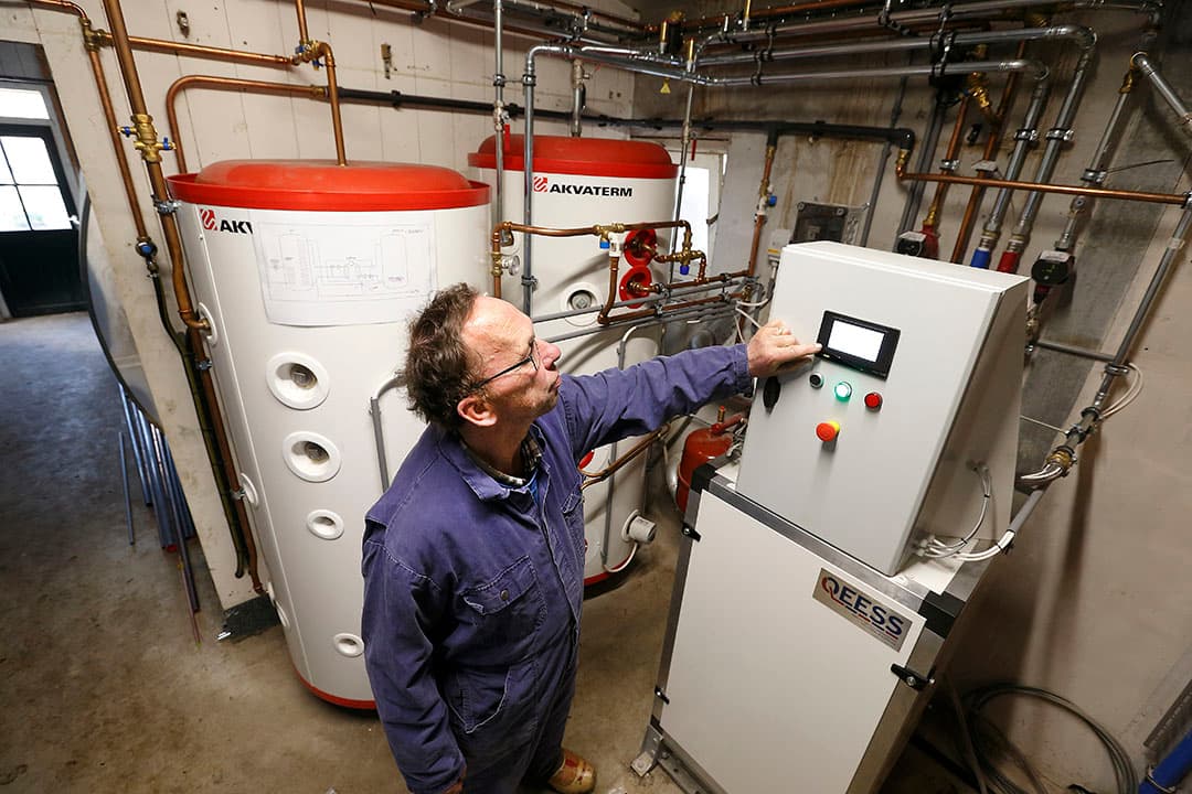 Gerhard Meijerink controleert de instellingen van de Hoge Temperatuur warmtepomp. Deze zet water van 45 graden om naar 85 graden. - Foto's: Hans Prinsen