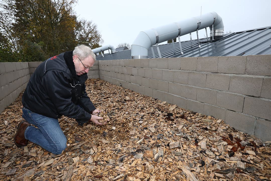 Jan Waaijer, directeur van JWEspo en leverancier van het luchtfilter controleert het biobed dat uit drie verschillende lagen houtsnippers bestaat. - Foto's: Henk Riswick