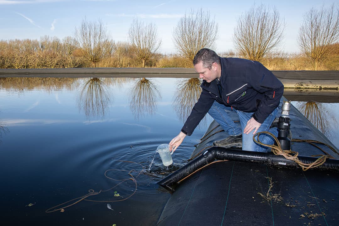 Eelco Boot neemt een monster uit het zoetwaterbassin, dat nodig is om gewasopbrengsten bij droogte op peil te houden. - Foto's: Peter Roek