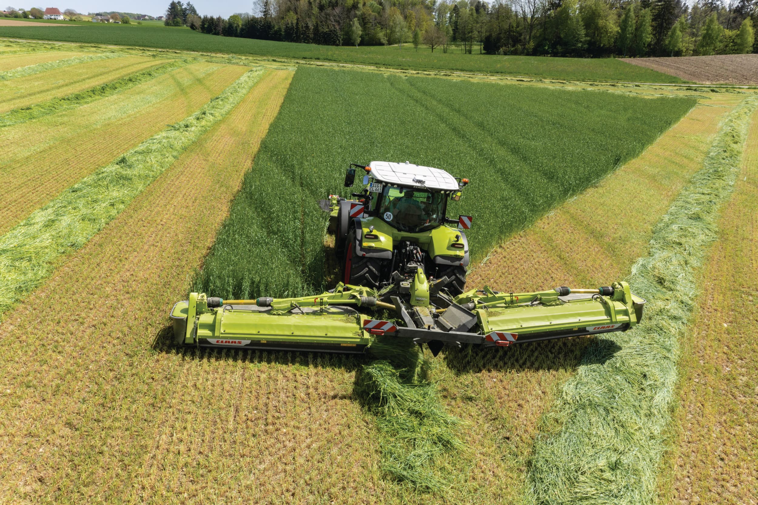 De Claas 9300 Direct Swather in actie. Achter de kneuzerloze maaiers zit een gesloten bak met daarin conische, mechanisch aangedreven vijzels. – Foto’s: Claas