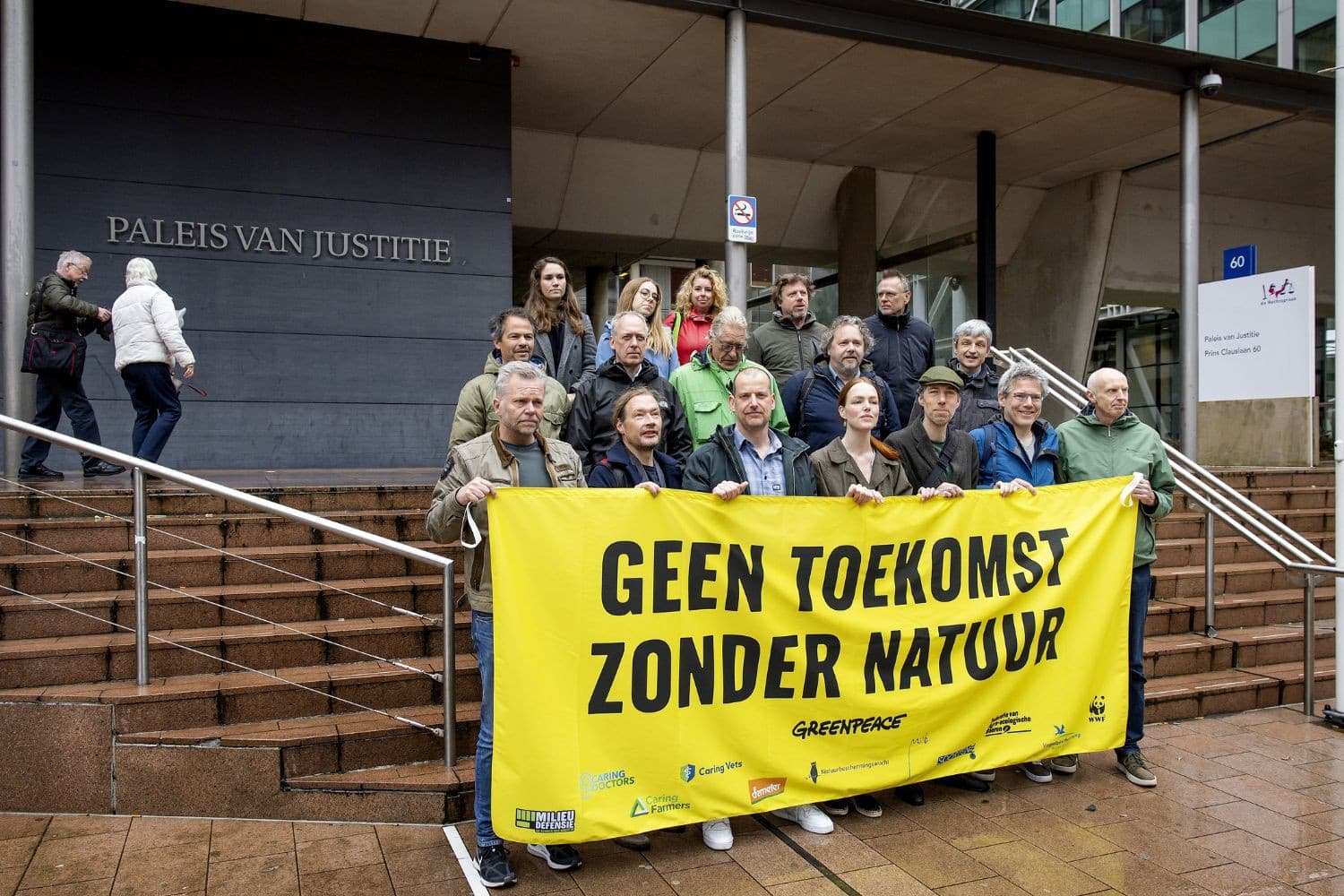 Greenpeace-directeur Andy Palmen (midden) en medestanders demonstreren bij de rechtbank in Den Haag, waar het kort geding tegen het stikstofbeleid van de regering plaatsvond. – Foto: ANP