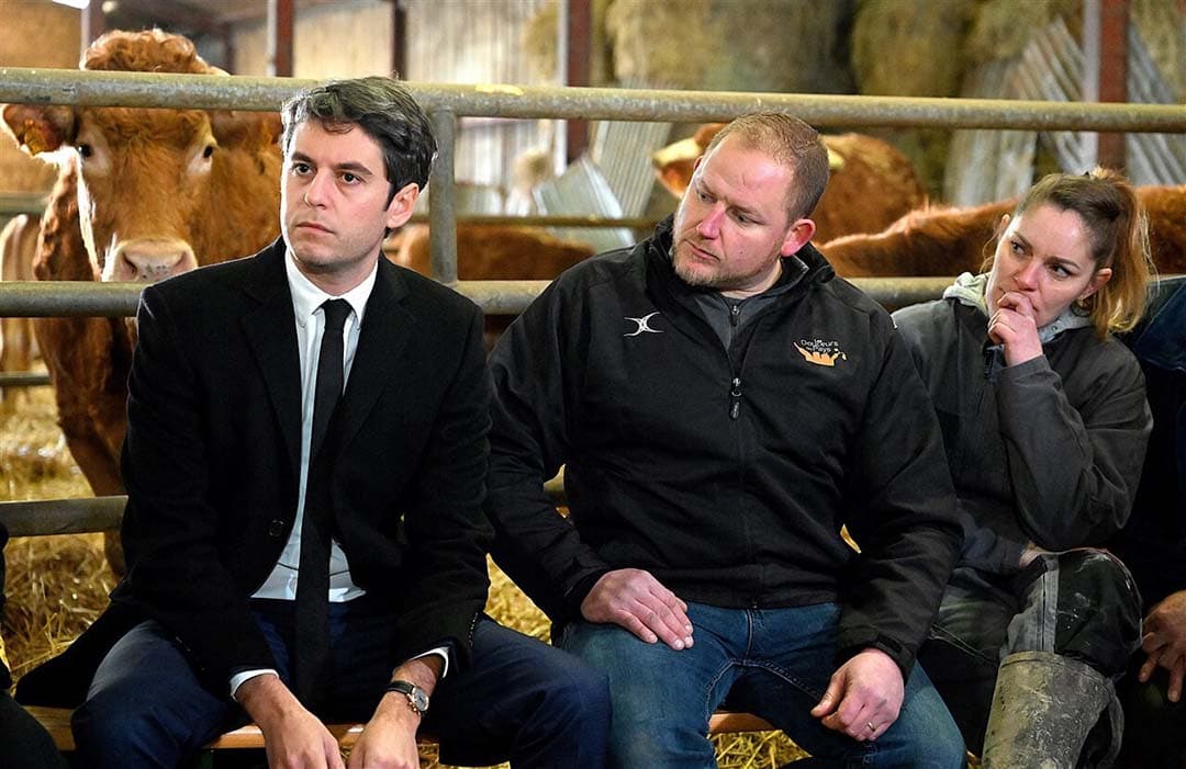 Premier Gabriel Attal luistert naar veehouders tijdens zijn bezoek aan een boerderij in Janvilliers, op zo'n 100 kilometer ten oosten van Parijs, op 15 februari 2024. - Foto: ANP
