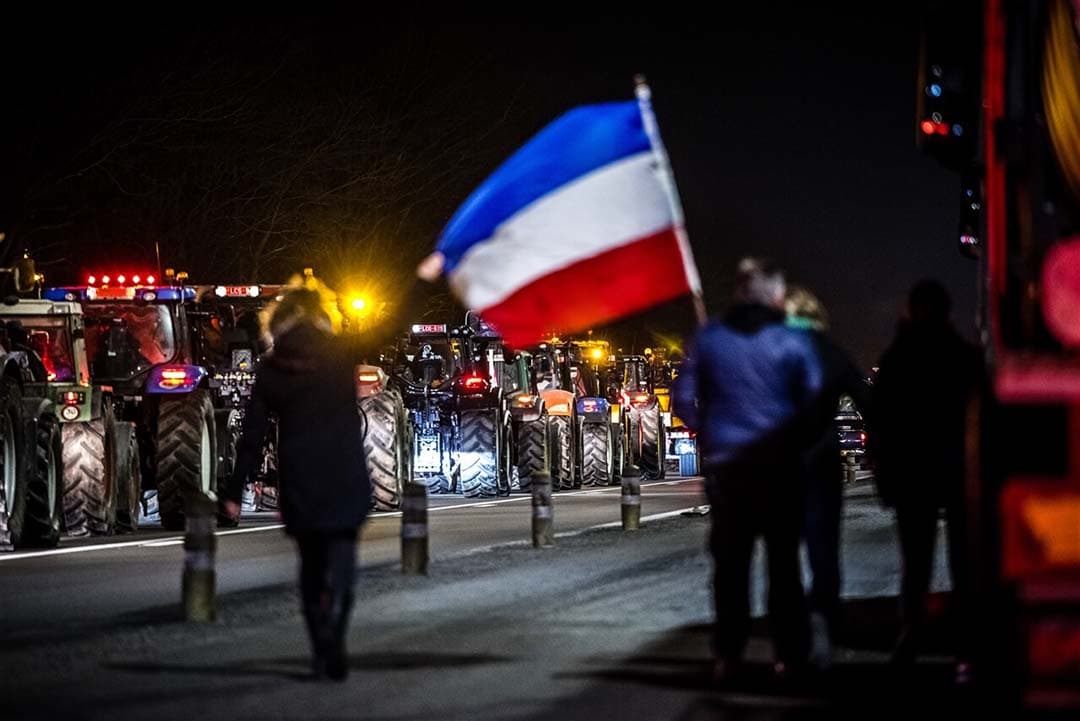 Nederlandse boeren met een vlag protesteren op de snelweg bij de grens met Nederland, 1 februari. Brabantse en Limburgse boeren voeren actie om Belgische boeren te steunen, die demonstreren tegen landbouwregels die volgens hen te streng zijn. - Foto: ANP