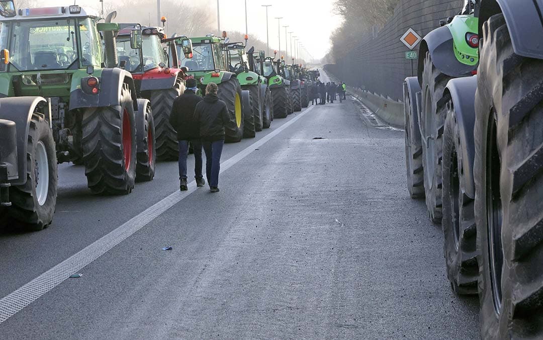 Boeren protesteren tegen het Europese landbouwbeleid, zoals hier op de snelweg E40 in België. - Foto: ANP