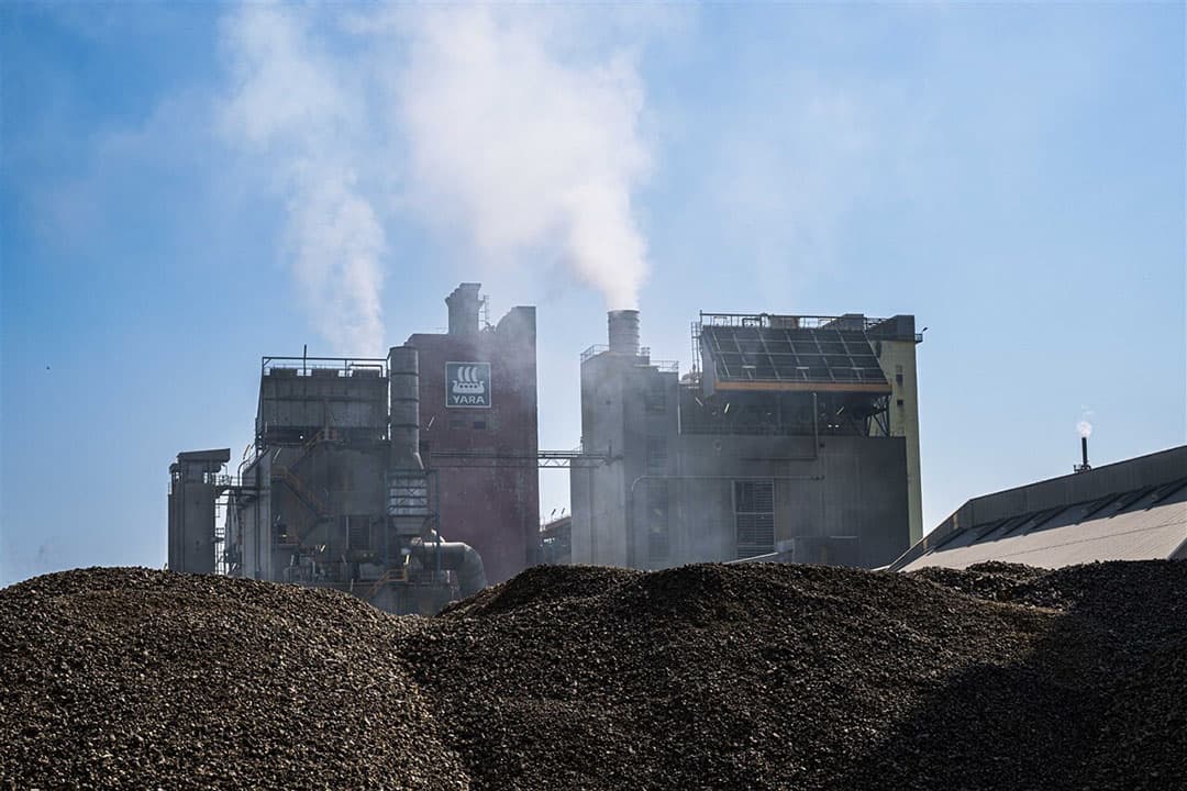 Kalk en erachter de productie van nitraat, beide gebruikt als vulstof bij kunstmestfabriek Yara. – Foto: ANP