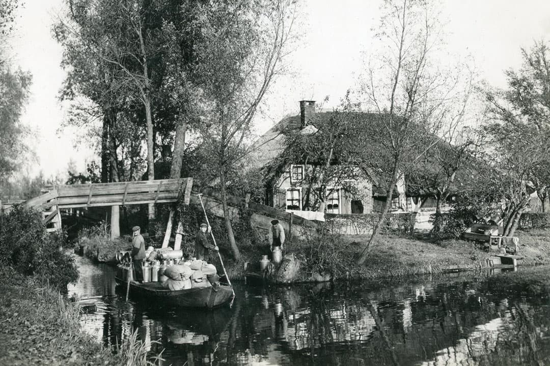 De melkvaarder in 1954, navigerend door de waterwegen van Giethoorn, waar transport per boot de norm was. - Foto: Misset