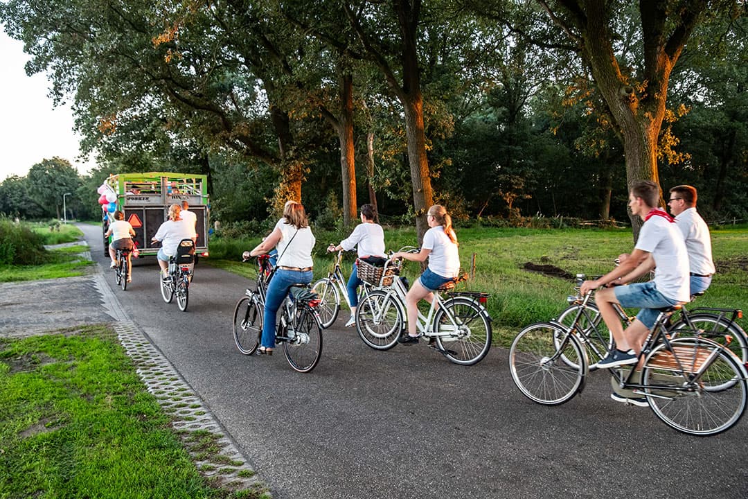 De buren hebben op afspraak allemaal een wit shirt aan. Vlak voor ze er zijn, parkeren ze in de wei van de bruidegom.
