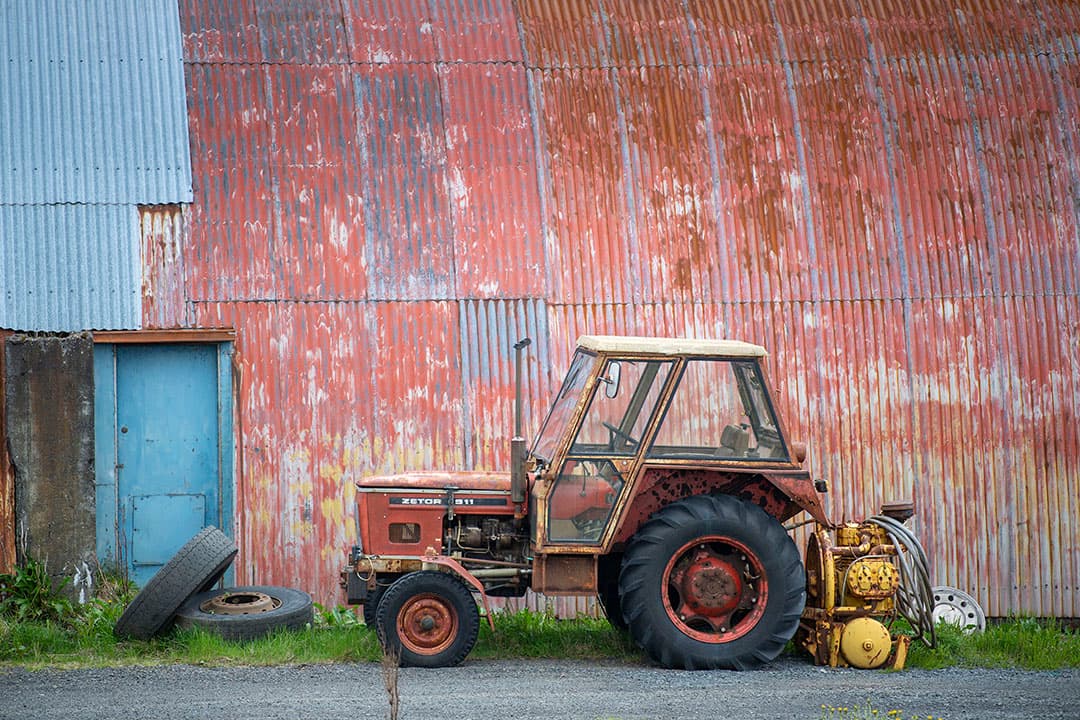 Deze Zetor 5911 met een aftakas-aangedreven compressor staat naast een loods geparkeerd. Het levert een mooie kleurencombinatie op.