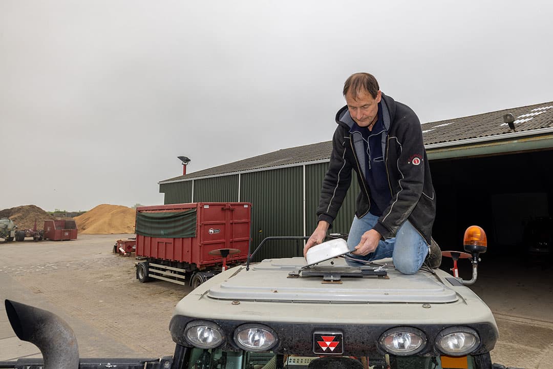 Chris Markusse monteert een gps-ontvanger op één van zijn trekkers.
