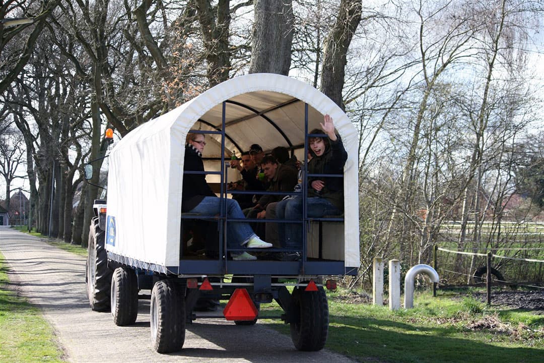 Mag ik met mijn trekker mensen vervoeren met huifkar of platte wagen? Het antwoord is: ja. Er gelden wel strikte regels. - Foto: ANP