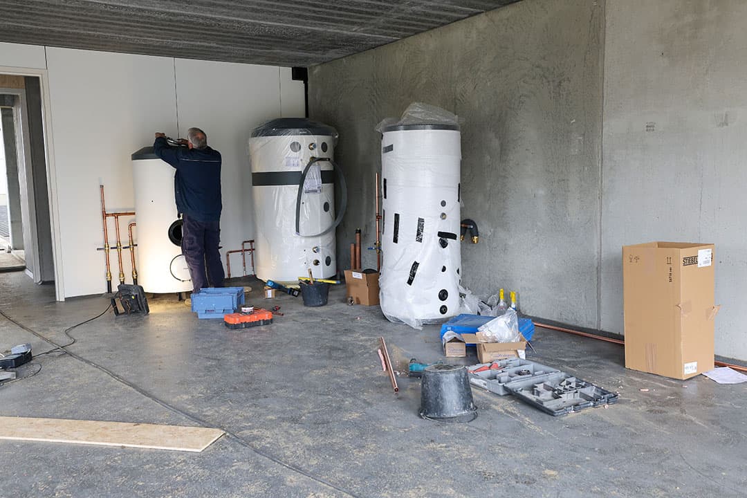 Dit zijn tanks voor de terugwinning van warmte uit melk. Er is een boiler die het voorverwarmde water op temperatuur brengt voor de reiniging van de melkrobot en melktank. Ook de grote tank voor de verwarming van het voorgebouw is zichtbaar. Die wordt aangesloten op een warmtepomp die buiten komt te staan.