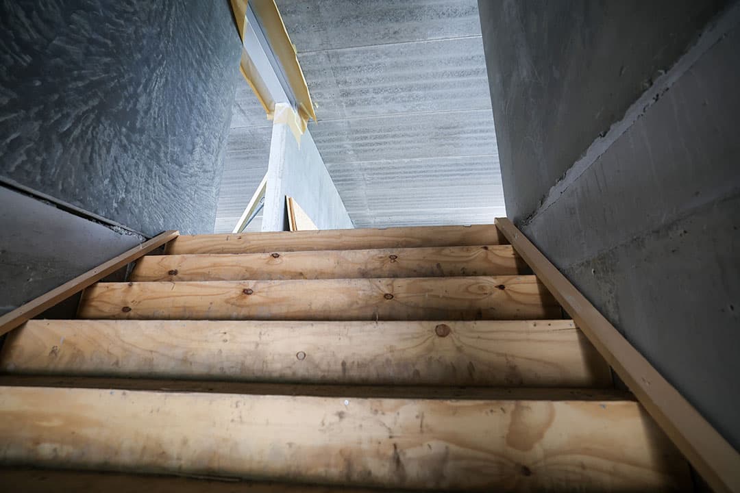De betonnen trap naar de eerste verdieping is ter bescherming voor de bouwwerkzaamheden met hout bekleed.