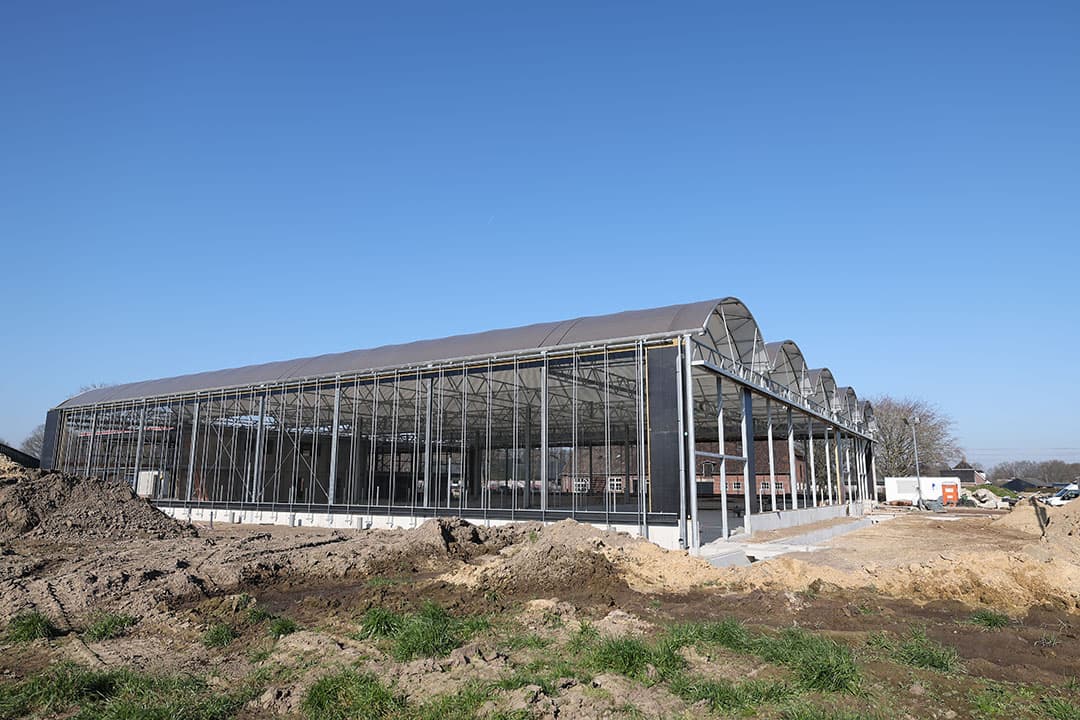Het beton in de koeientuin is gestort, de bogen van het serrestaldak zijn geplaatst. Nu gaan de bouwmedewerkers beton storten in het voorgebouw.