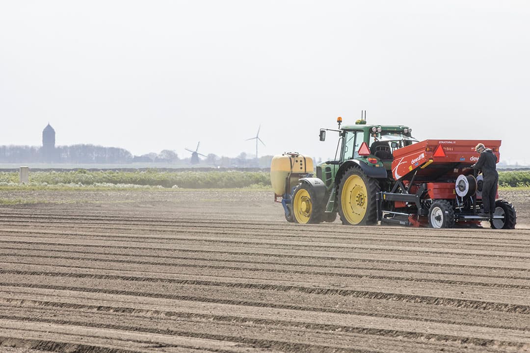 Aardappelen poten met tegelijkertijd het leggen van irrigatieslangen. Extra werk, maar in ieder geval planbaar. - Foto: Koos Groenewold