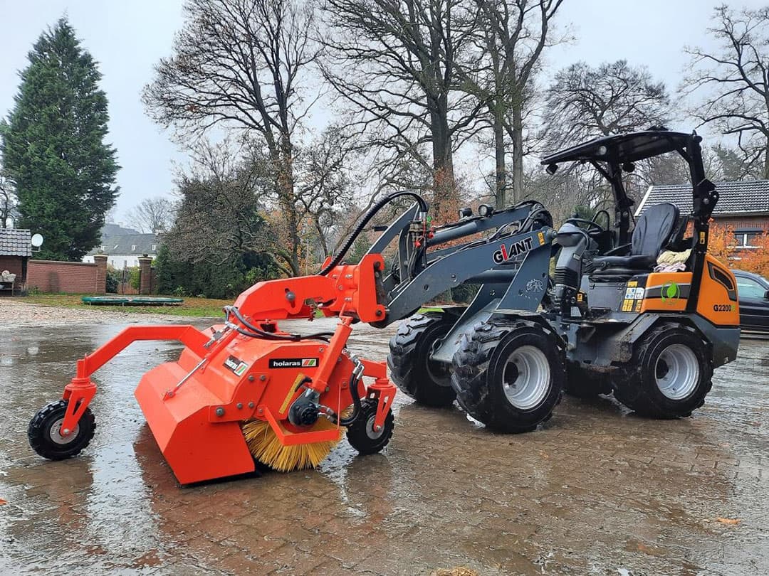 Machinefabrikant Holaras heeft de H150-veegmachine speciaal ontworpen voor de mini-shovel. De veegmachine rust op drie zwaar uitgevoerde zwenkwielen. - Foto: Holaras