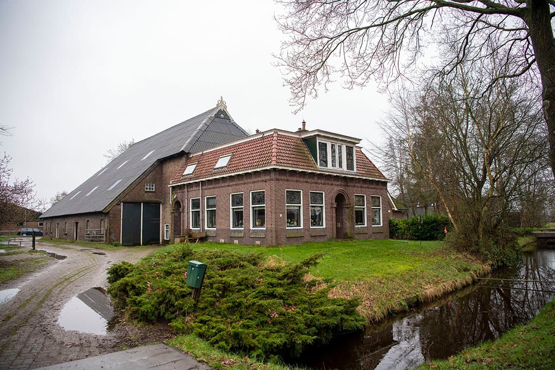 Buitenaanzicht van de boerderij die vroeger alleen per boot bereikbaar was.