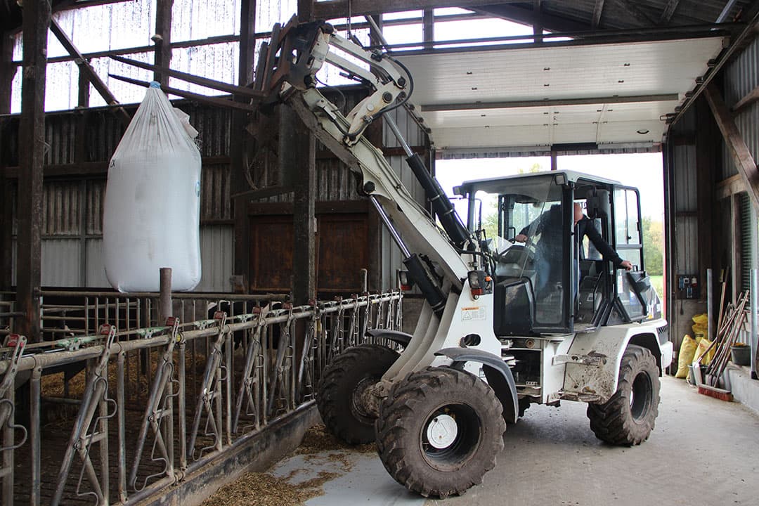 Met een minishovel tilt Harms een bigbag boven de roosters om Eminex te verdelen. Daarvoor is een speciale dosator beschikbaar, zodat de zak niet ineens leegloopt. - Foto's: Kees van Dooren