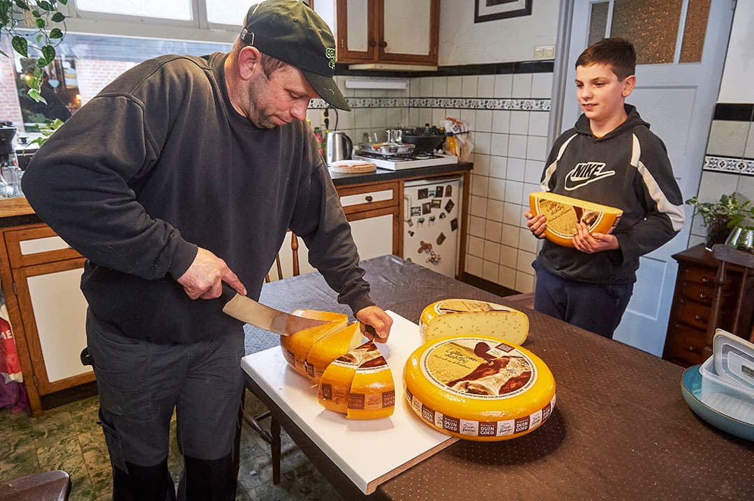 Een van de deelnemende veehouders aan de zuivelcoöperatie snijdt eigengemaakte kaas voor de klanten. - Archieffoto: Van Assendelft