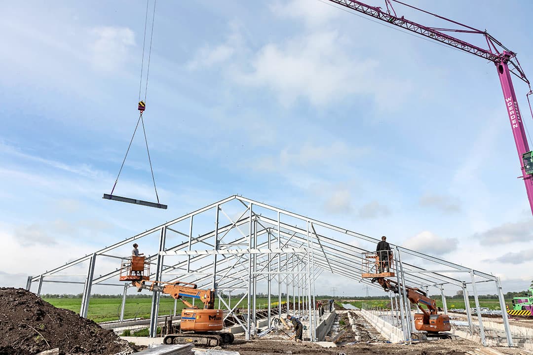 Bouw van een nieuwe stal. Voor bedrijven die gebouwd hebben met een PAS-vergunning is de vraag hoe zeker zij zijn van die vergunning sinds de PAS gesneuveld is bij de rechter. - Foto: Herbert Wiggerman