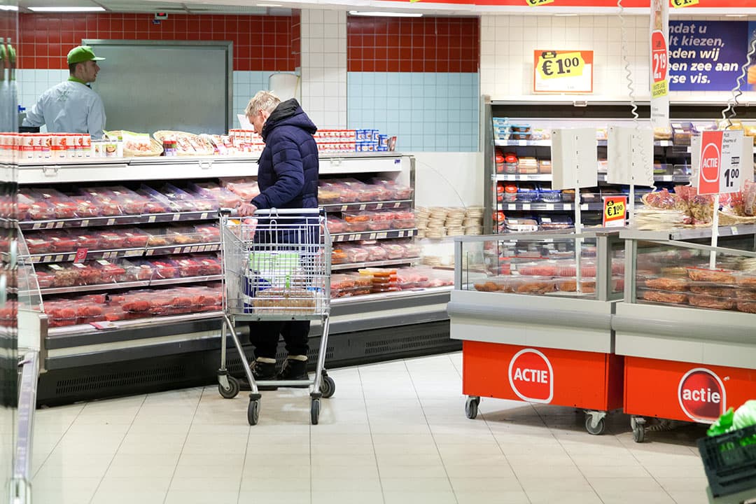 Een consument in de supermarkt bij het vleesschap. Uiterlijk 2025 moet de CFP van levensmiddelen bekend zijn. Voor varkensvlees is dat dit jaar al een mogelijkheid.