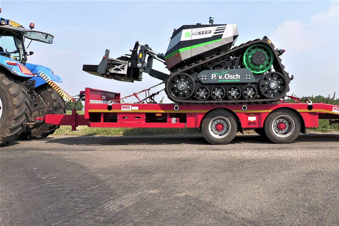 Met een dieplader wordt de Agxeed-robottrekker naar het perceel gereden. Groenteteler Peter van Osch in Leunen (L.) wil met de AgXeed-robottrekker intensieve bewerkingen als schijveneggen, diepwoelen en frezen uitvoeren in de teelt van sla en lelies. - Foto's en video: Annelies Bakker