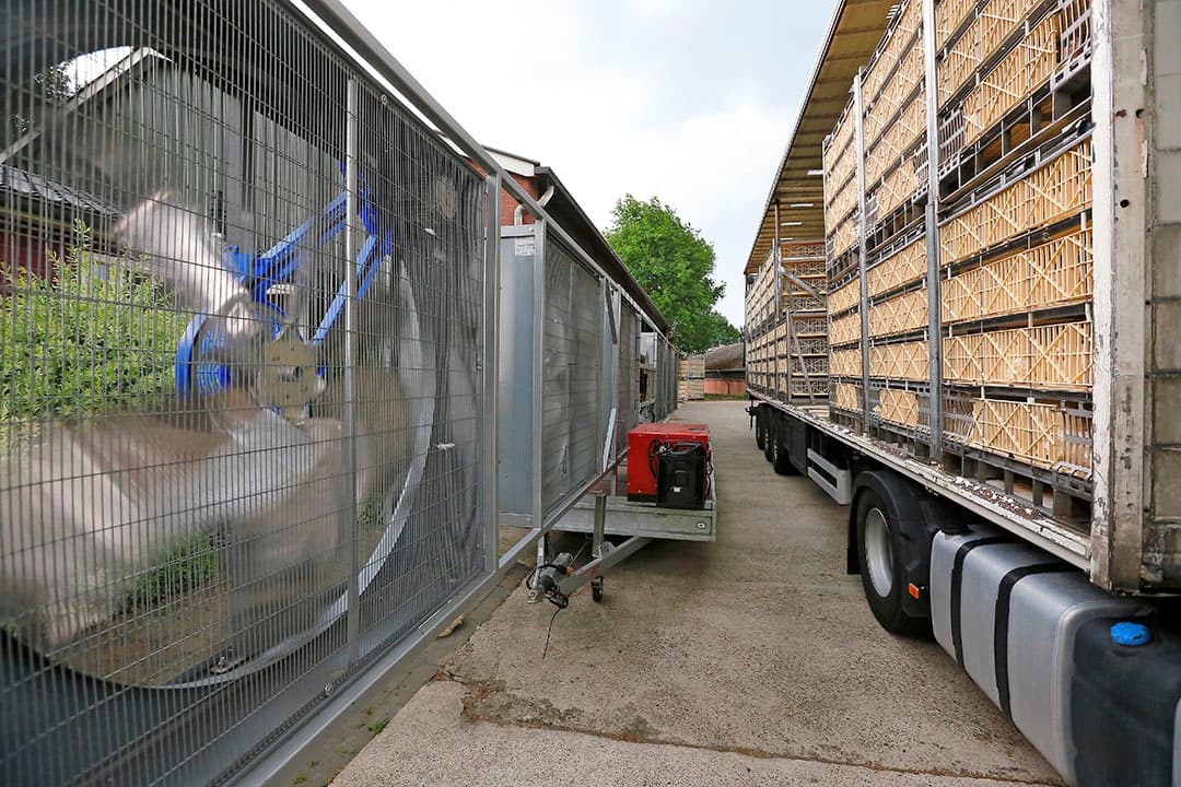 Een aanhanger met zes grote ventilatoren zorgt voor verkoeling tijdens het laden van de kuikens. - Foto: Hans Prinsen
