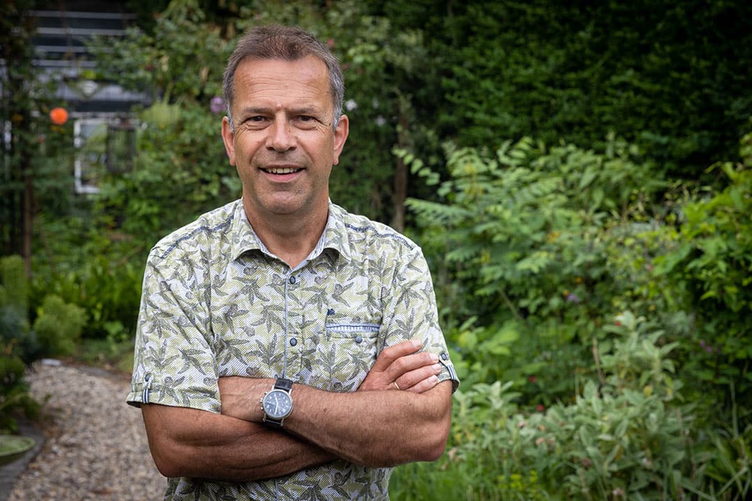 Erno Bouma (61) bij een 'weerpaaltje' (Field Mate) in zijn eigen tuin, dat weerdata doorgeeft. Een akkerbouwer krijgt aan de hand van data, die het paaltje doorgeeft vanaf een perceel, een advies welke middelen hij op welk moment het beste kan toepassen. - Foto: Koos Groenewold