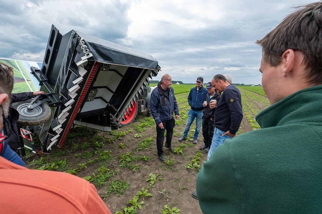 Deelnemers aan de praktijkdag bieten krijgen uitleg bij de ARA spotsprayer van EcoRobotix. De machine heeft op 6 meter 156 computer aangestuurde spuitdoppen en kan zo heel gericht spuiten. - Foto: Jan Willem van Vliet