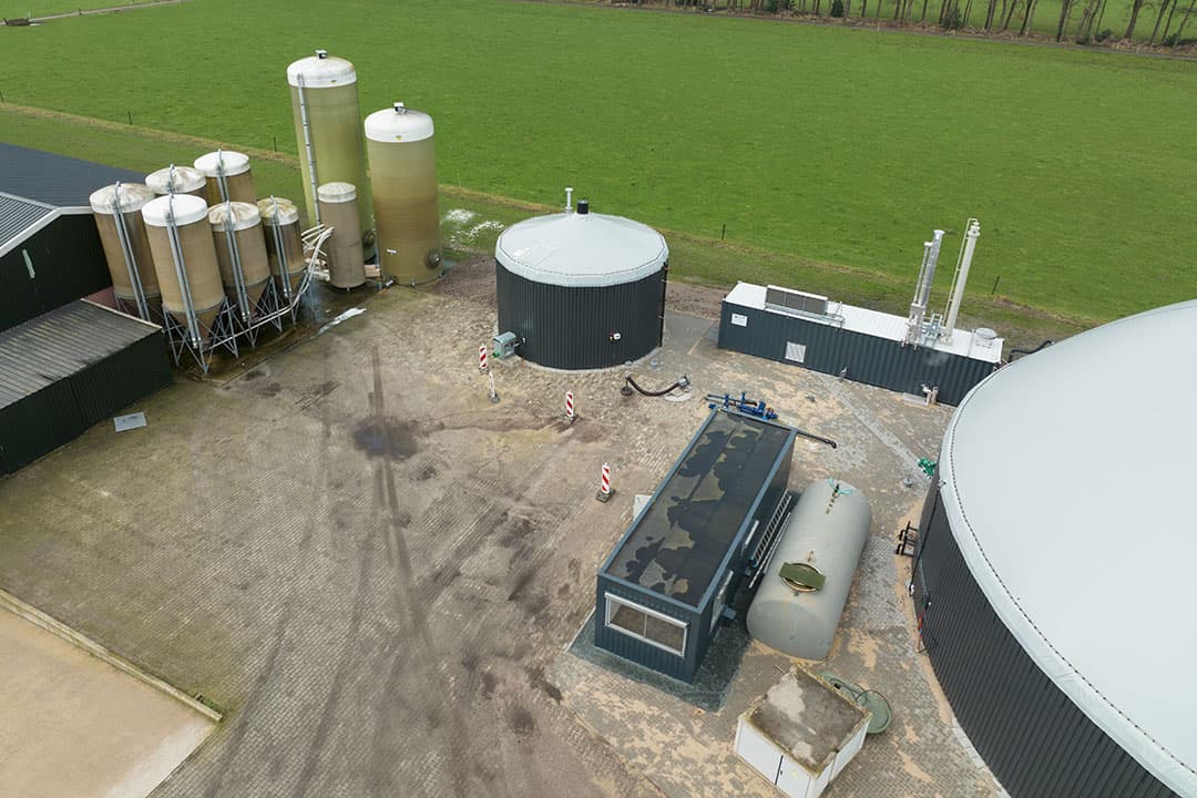 De monomestvergister in Hoge Hexel draait 100% op mest, zonder hulpstoffen. Achter staat de container met de techniek om vergistingsgas op te waarderen tot aardgaskwaliteit. - Foto: Michel Velderman