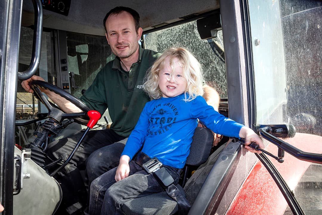 Thijs, het zoontje van melkveehouder Siem van Leeuwen uit Heenvliet (ZH) gaat graag mee op de trekker. De dealer monteerde daarvoor een apart zitje in de cabine.  - Foto: Dennis Wisse