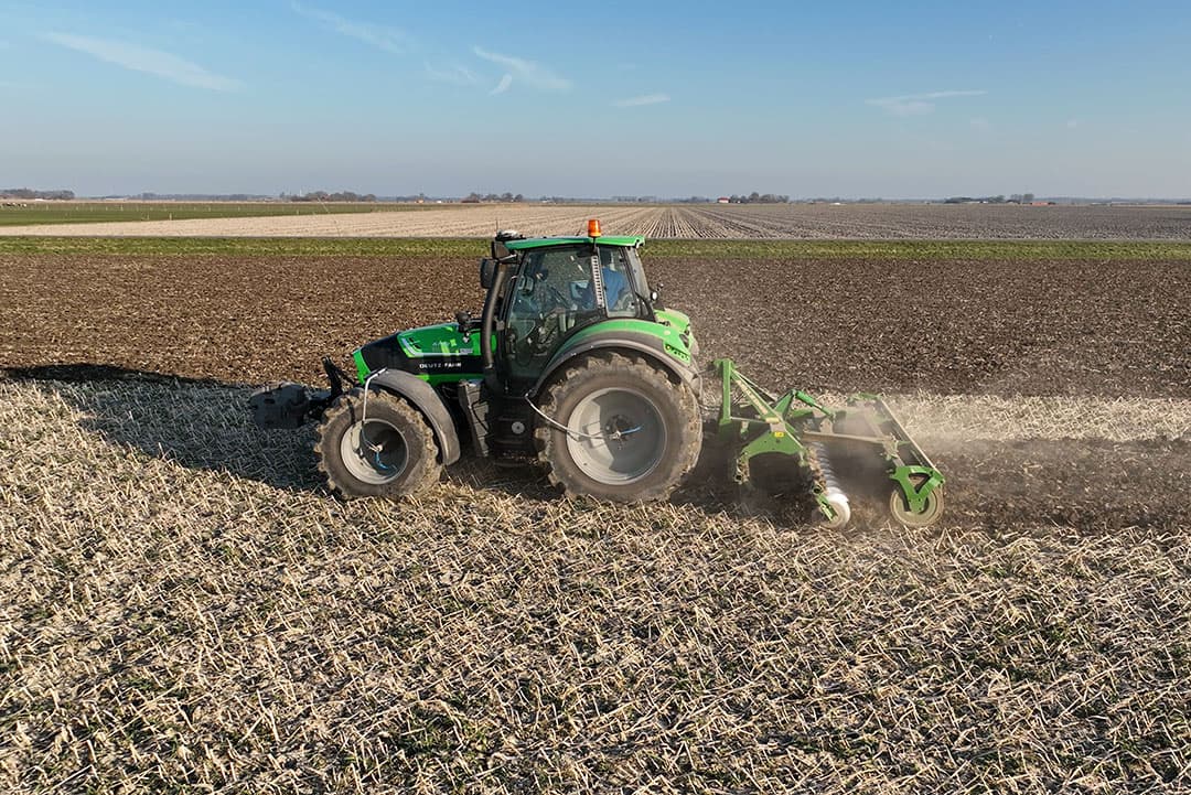 Met een schijveneg bewerkt Randolf Schulte een bladrammenas groenbemester. De grond kan nu verder opdrogen. Op de achtergrond een op wintervoor geploegd perceel. - Foto's: Sytze Bakker