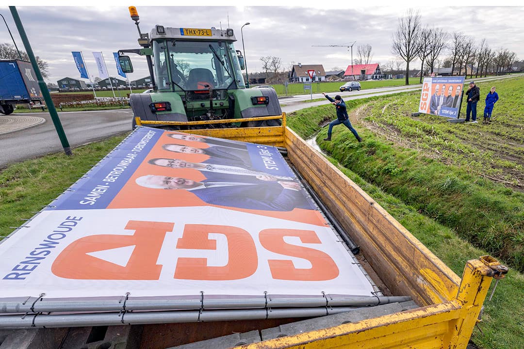 Veehouder Harmen Hardeman is bezig met het plaatsen een verkiezingsbord voor de gemeenteraadsverkiezingen. Net als veel andere boeren stelt hij zichzelf kandidaat, in zijn geval voor SGP in Renswoude (Gld.) - Foto: APA