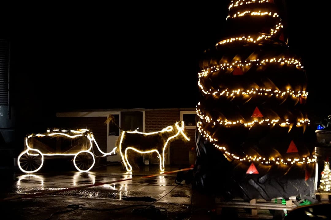 Een verlichte 'kerstboom' van trekkerbanden. - Foto: Rachel Henst