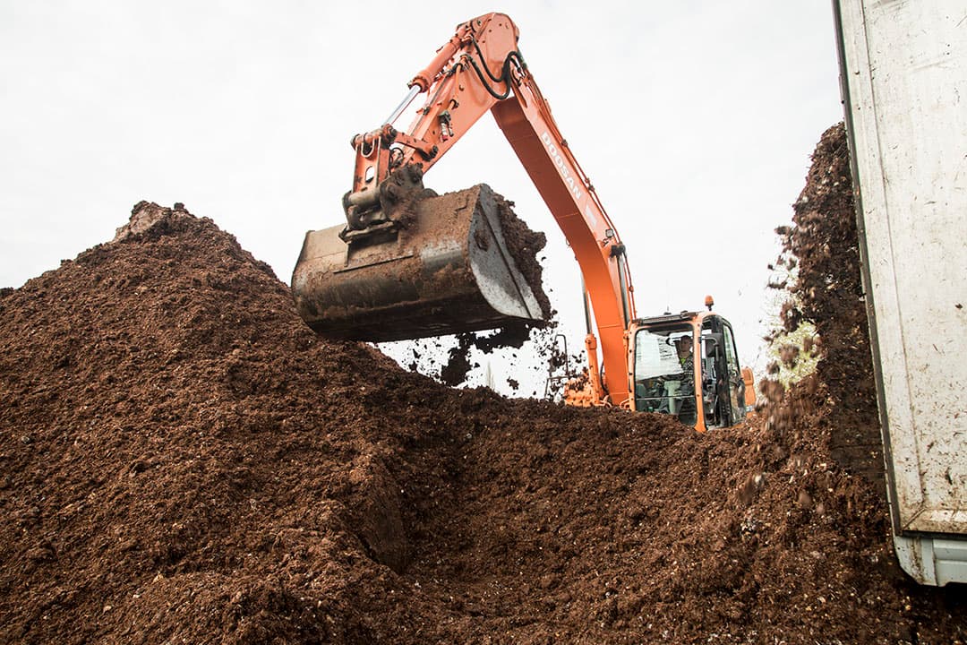 Lossen van compost. Een deel van de in Nederland geleverde compost voldoet ondanks certificering niet aan de voedselveiligheids eisen. - Foto: Koos Groenewold