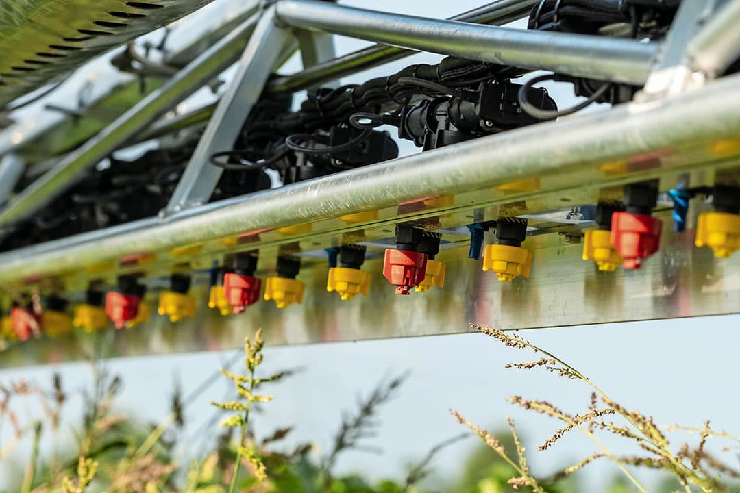 Door een van de dophouders (op 50 centimeter afstand onderling) van een tweedoppenschakeling te splitsen naar twee nieuwe dophouders op 25 centimeter, kan Agromec een bestaande Rogator-spuit ‘upgraden’ zodat die ook met een driftreductie van maximaal 97,5% kan spuiten. - Foto: Abemec
