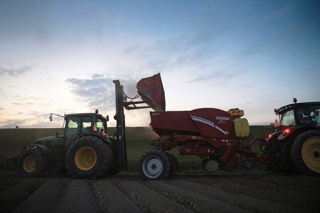 Aardappelen poten onder donkere omstandigheden. Typerend voor de situatie in het voorjaar van 2020 toen corona de markt in haar greep kreeg en hield. Tot eind juli 2021 zelfs toen de prijzen inmiddels gestegen waren. - Foto: Mark Pasveer