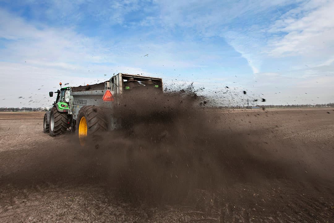 Uitrijden van compost. Regelmatig toedienen van verse organische stof stimuleert het bodemleven waardoor een bodem weerbaarder wordt. - Foto: Hans Banus