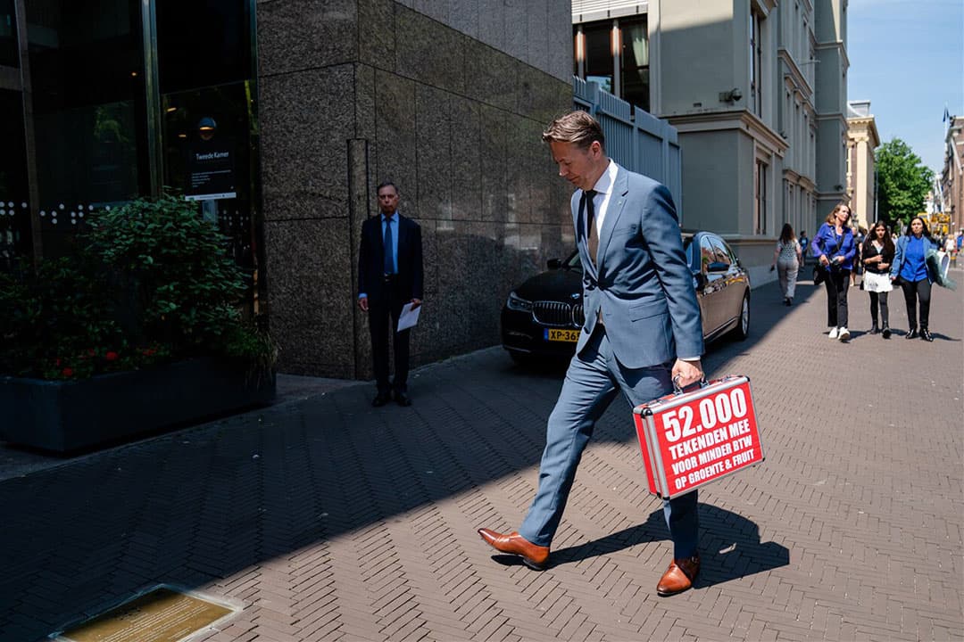 Marcel Huizing, algemeen directeur Dirk van den Broek, overhandigt een petitie aan kamerleden van de commissie Financien voor minder btw op groente en fruit. - Foto: ANP