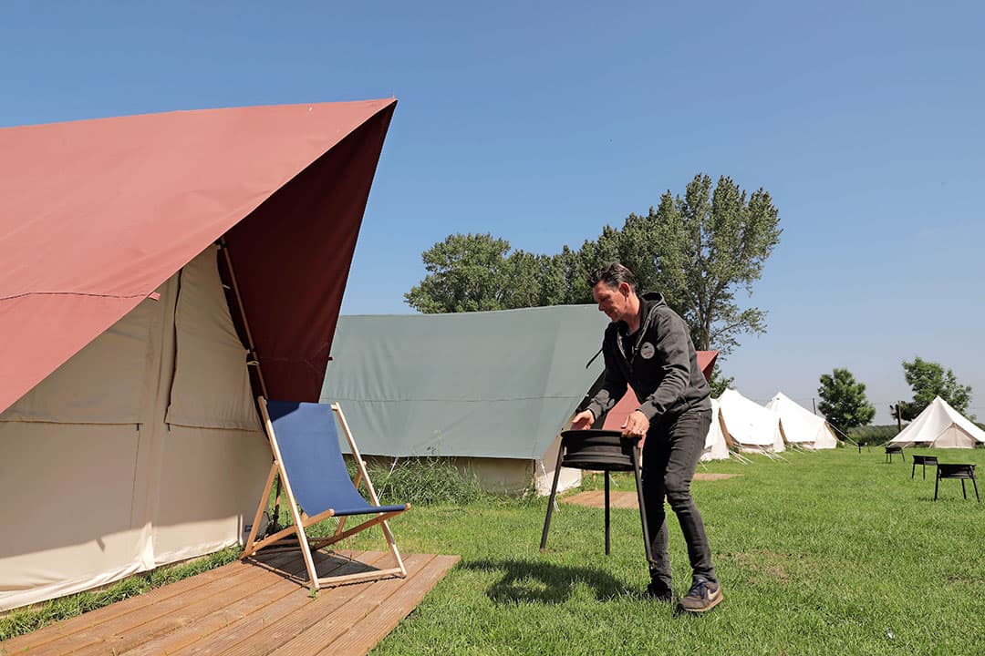 De bbq wordt klaargezet door Dinand Garritsen op de pas geopende FarmGlamping De Scheurwei in Toldijk. - Foto: Michel Zoeter