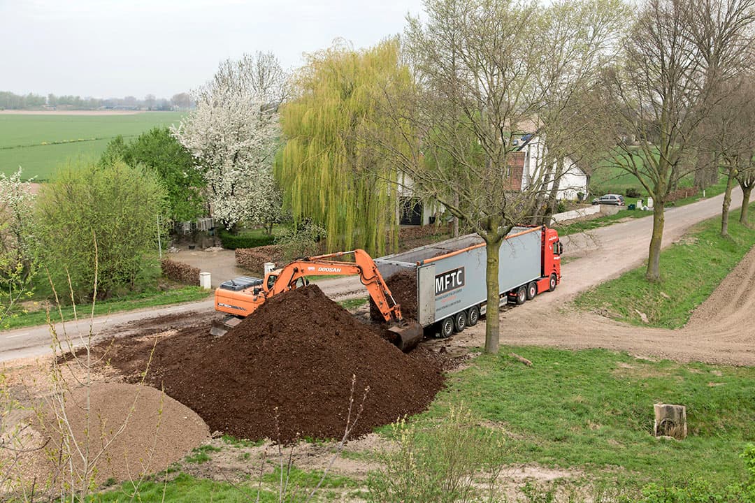 Lossen van compost op akkerbouwperceel. - Foto:
