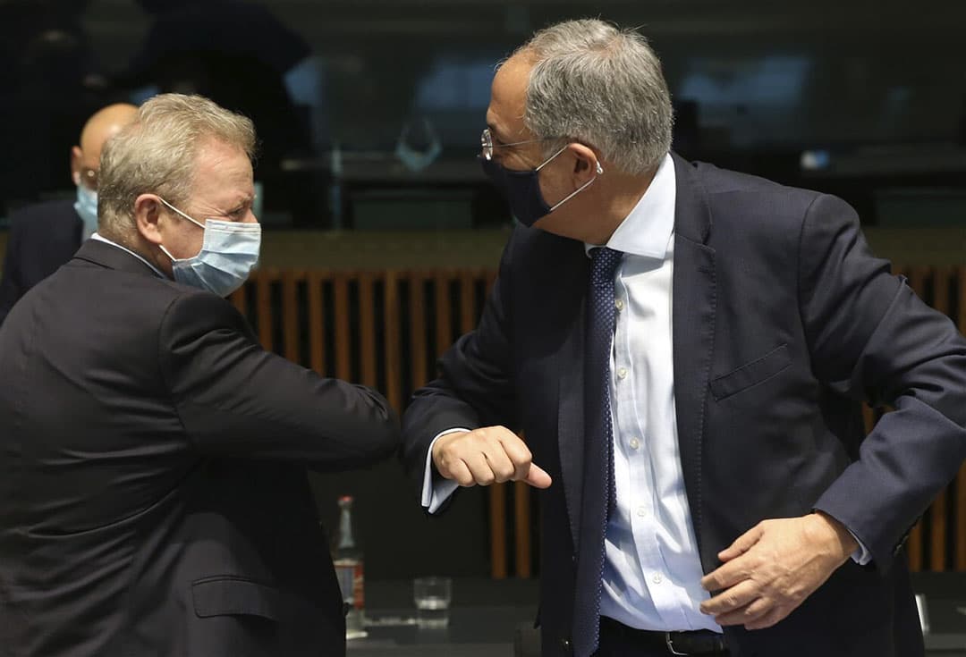Janusz Wojciechowski, links, groet de Cypriotische landbouwminister Costas Kadis met de elleboog. - Foto: AP